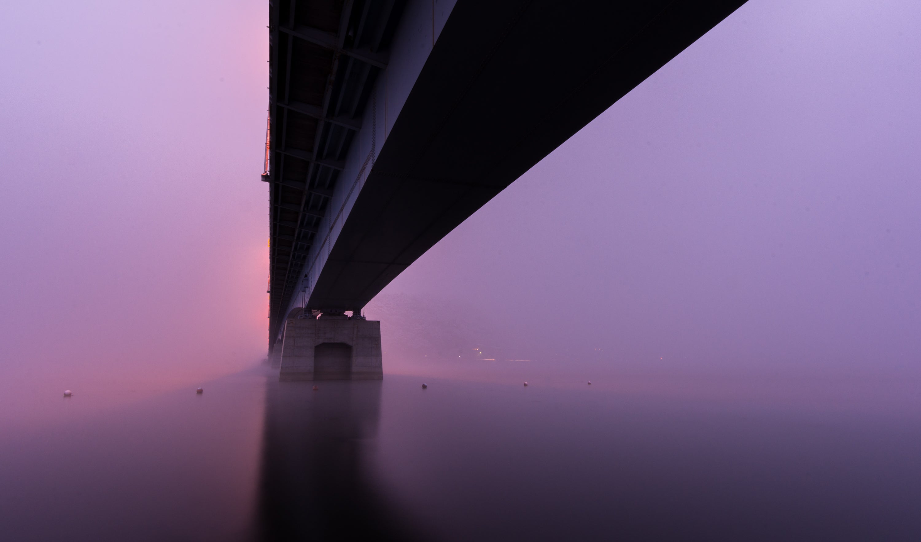 a-bridge-sitting-in-thick-pink-and-purple-fog.jpg
